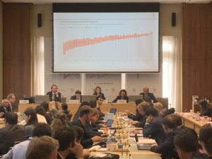 WTO Public Forum: lange Tischreihe mit Screen